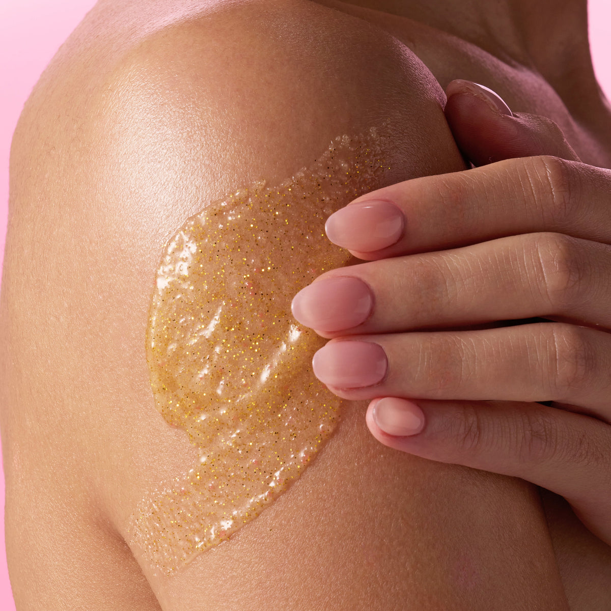 woman applying Tree Hut Golden Vanilla Shea Sugar Scrub 18oz to the side of arm, showing consistency and how product sits on skin