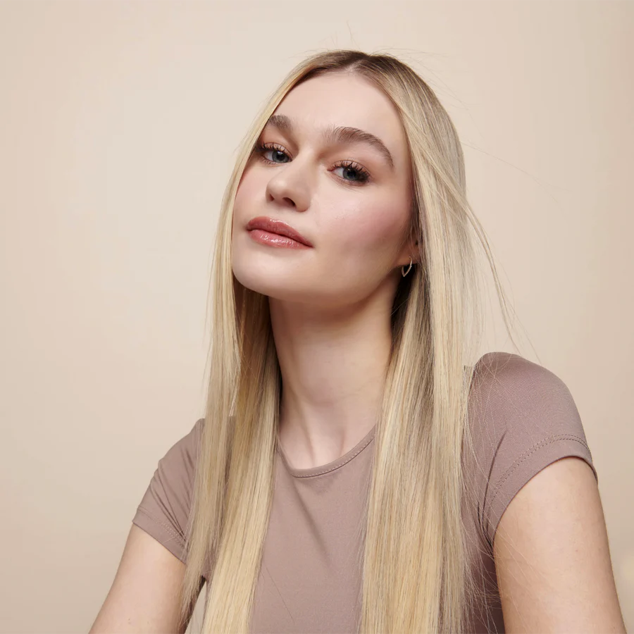 Model with smooth, shiny, frizz-free blonde hair styled using Umberto Giannini WeatherProof Finish Anti-Humidity Frizz Free Hairspray for all-day humidity protection.
