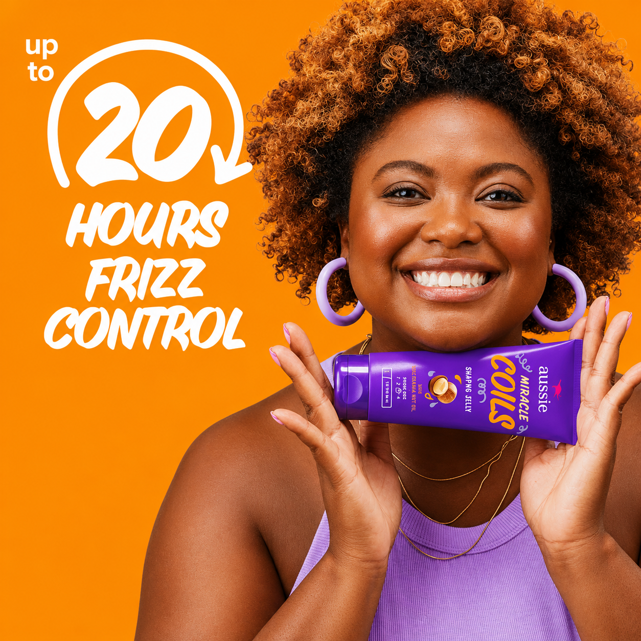 a promotional image featuring a smiling woman with natural coily hair holding aussie miracle coils shaping jelly in a purple tube against a bright orange background. bold white text highlights "up to 20 hours frizz control", showcasing long-lasting hold and definition for coily hair.
