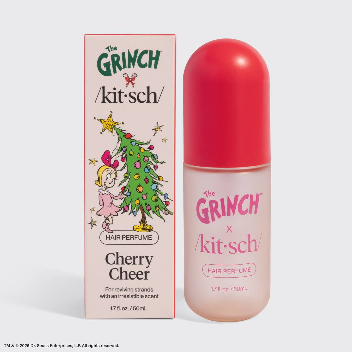 The Grinch x kitsch Cherry Cheer hair perfume set, featuring a pink and white illustrated box next to a clear bottle with a bright red cap, on a light gray background.