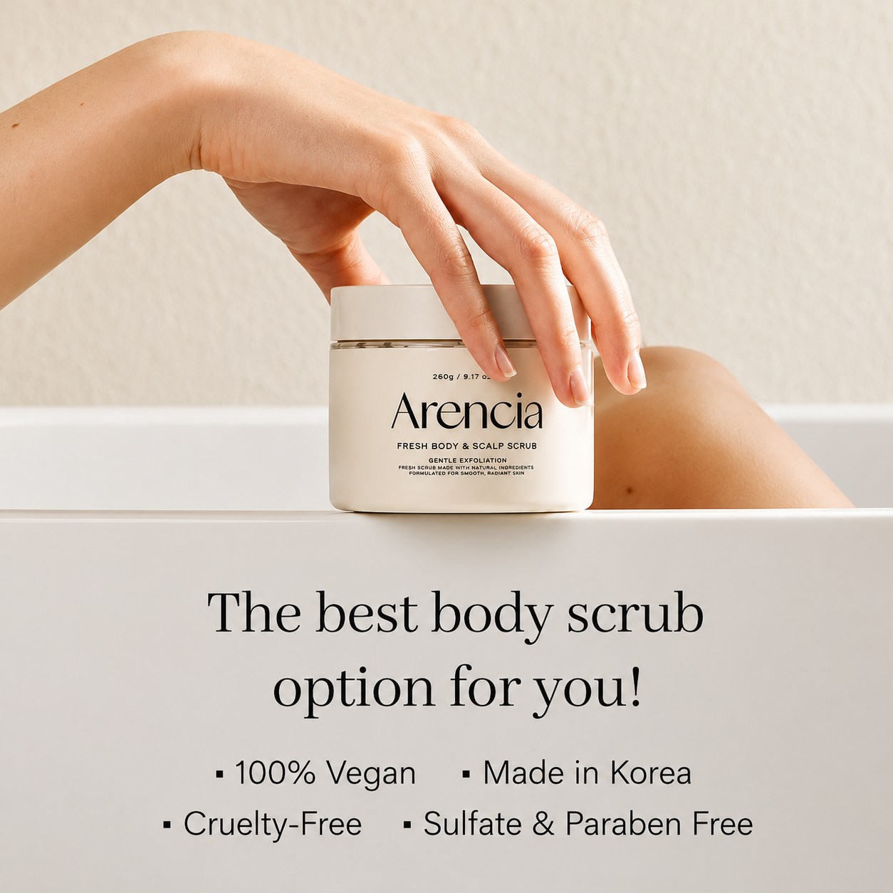 arencia fresh body & scalp scrub displayed on the edge of a white bathtub with a hand resting on the lid, highlighting its vegan, cruelty-free, sulfate-free, and paraben-free formula in a clean, minimalist bathroom setting.