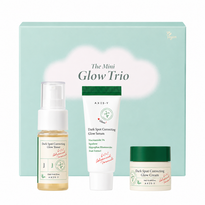 axis-y the mini glow trio skincare gift set featuring travel-size dark spot correcting glow toner, glow serum and glow cream in front of a pastel green gift box. brightening skincare set formulated with niacinamide, squalane and sea buckthorn fruit extract to hydrate skin and help improve the appearance of dark spots and uneven skin tone.