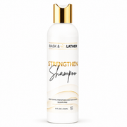 bask & lather strengthen shampoo 236ml in a white bottle with a gold cap, formulated to deeply cleanse, strengthen, and moisturize hair with a sulfate-free formula that helps leave hair feeling soft, healthy, and refreshed. displayed on a clean white background.