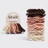 Stack of Kitsch hair elastics in various colors with packaging on a light gray background