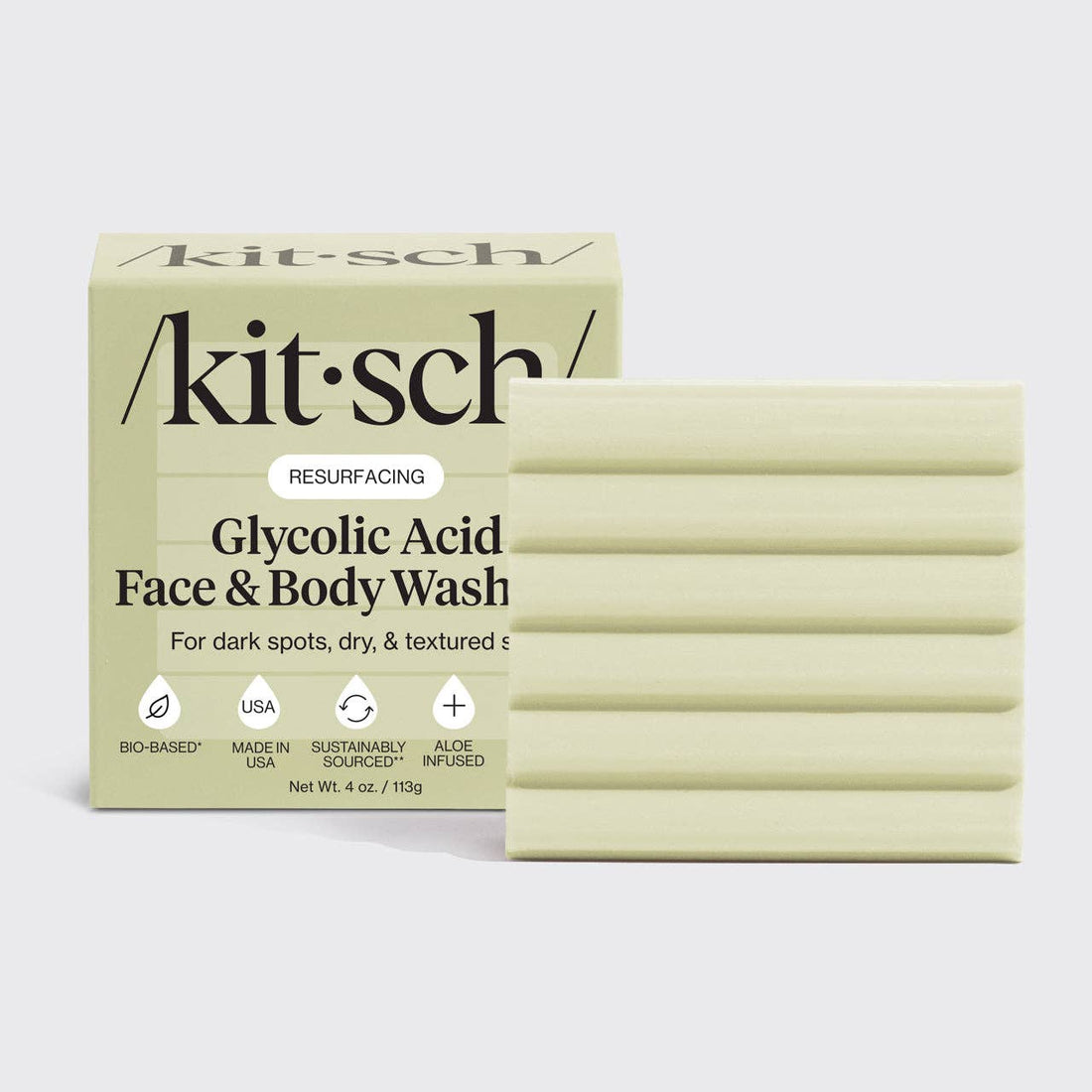 Kitsch glycolic acid face and body wash packaging with bars of soap on a light gray background