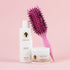 Bounce Curl hair care products including a bottle, a jar, and a pink brush on a pink background.