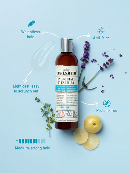Curlsmith hair product bottle with lavender and apple slices on a light blue background