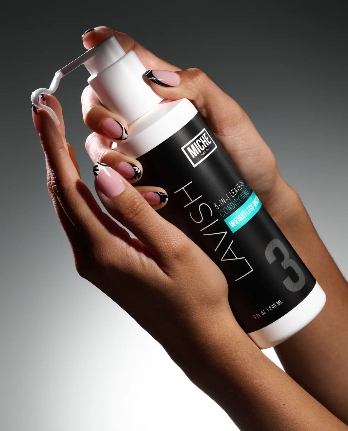 Hand holding a bottle of Miche Lavish hair care product against a gradient background