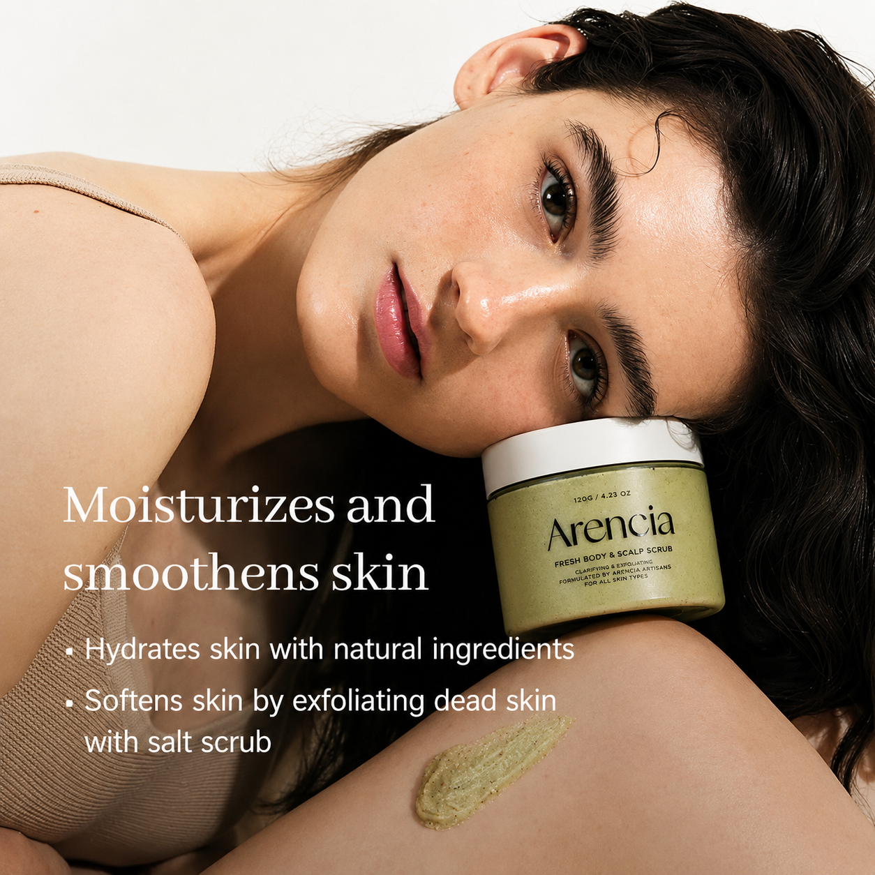 person reclining with an arencia fresh body & scalp scrub beside their face, highlighting hydrating, exfoliating benefits for smoother, softer-looking skin.