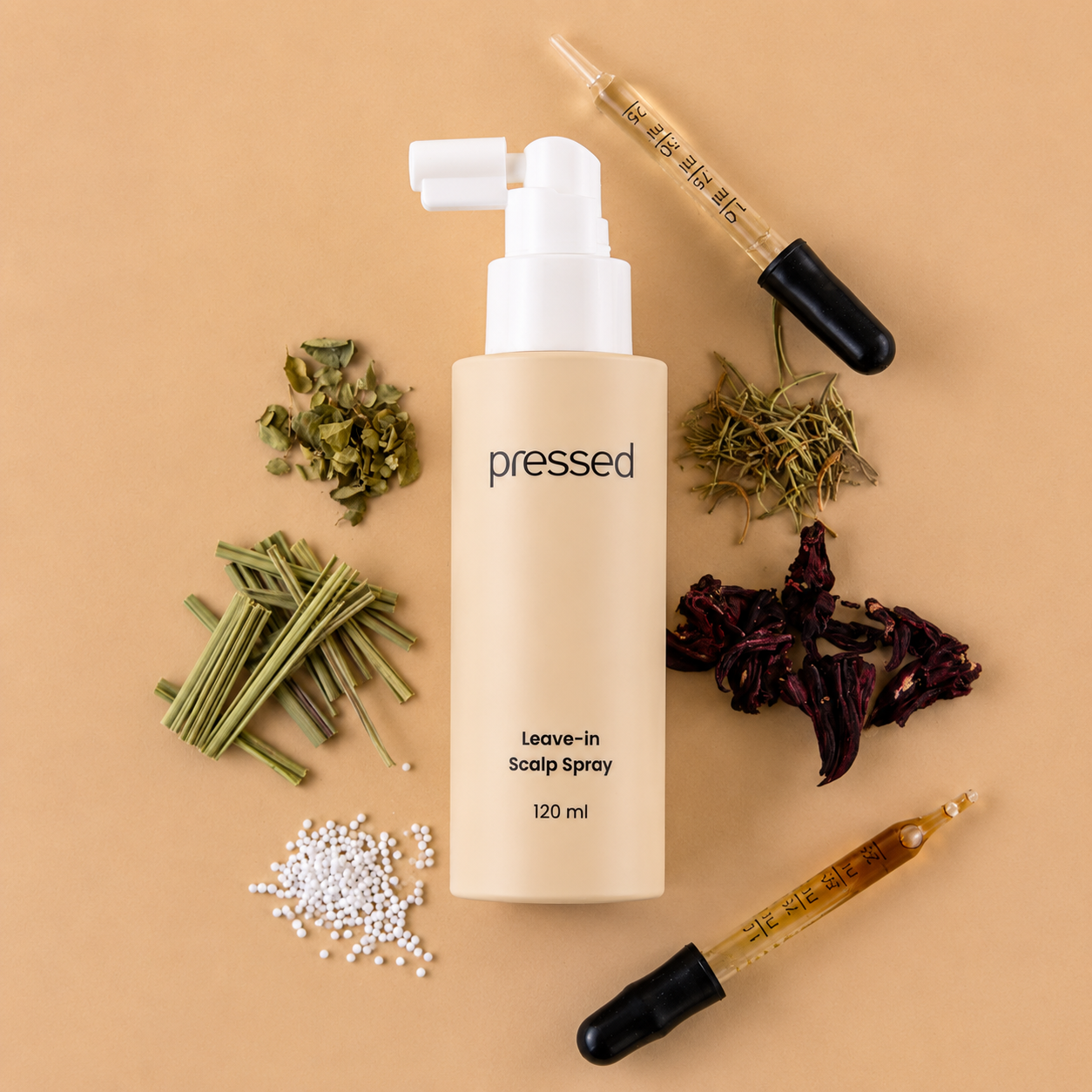 pressed leave-in scalp spray 120ml bottle surrounded by botanical ingredients and glass droppers on a beige background