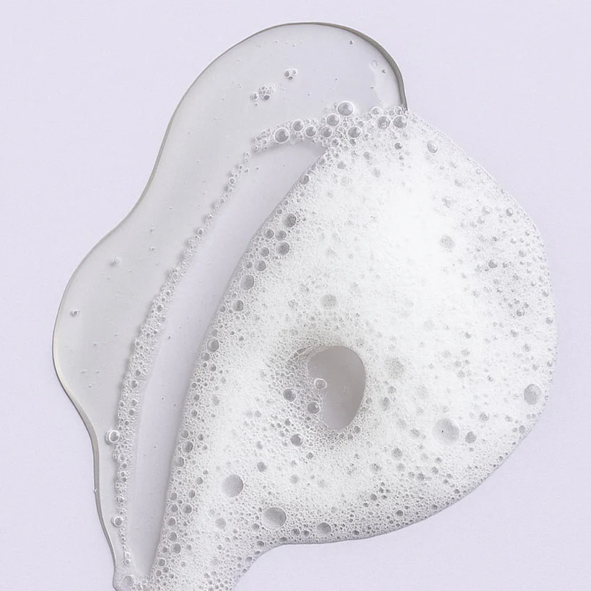Bali Curls Shampoo Foamy liquid with bubbles on a light purple background