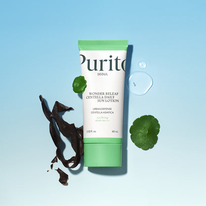 Tube of Purito Wonder Releaf Centella Asiatica Sun Lotion on a light blue background with green leaves and a drop of water.