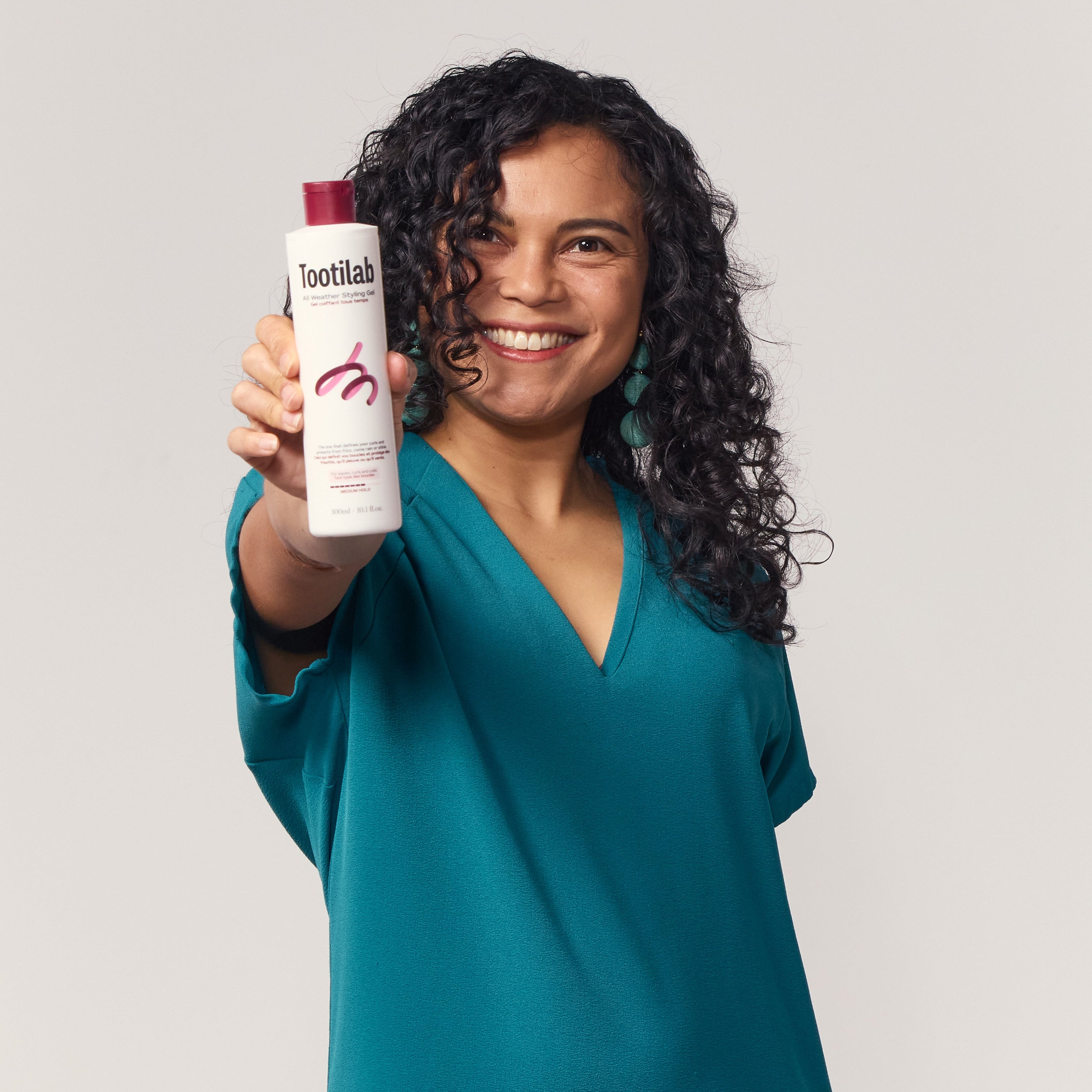 Woman holding a product labeled 'Toothlab' against a plain background